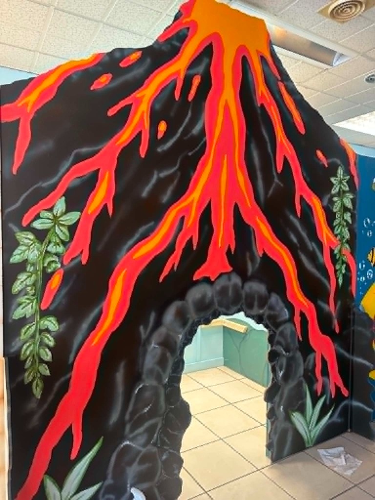 The painted volcano, with red lava down the sides and a cave opening at the bottom.